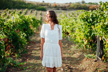 a beautiful woman picks berries in a vineyard