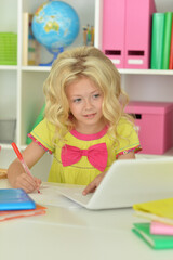 Beautiful girl using laptop at desk at home