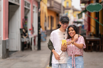 Naklejka premium Woman pointing at the mobile while walking in the street with a friend