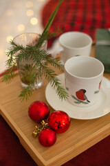 cup of tea with christmas candles and red candle on wooden background. top view.