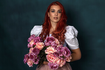 Red hear young beautifull woman with flowers on her hands