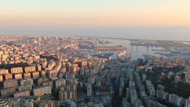 genova city aerial view drone at sunset italy,high wide shot of genova old town and port at dusk flying sideways 4k