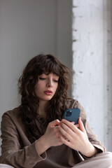 Fototapeta premium Attractive young woman with curly hair takes selfie.