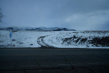 road and road signs against the backdrop of winter mountains