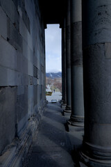 view of the alley and mountains through the columns of the ancient temple