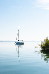 A sailboat is sleeping on the lake Balaton in the autumn light.