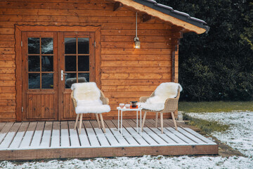 Nice wooden hut in a garden with snow. Garden shed with chairs in winter. Winter mood. Drinking tea...