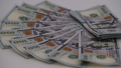 A sheet of new hundred dollar bills are laid out on the table, in a row and in a circle. Great background for filling.