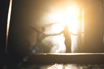Naklejka premium Couple of two professional ballroom dancers is dancing on loft studio. Beautiful art performance with heavy smoke. Sport life concept. Passion and emotional dance.