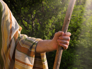 Man's hand with a wooden staff