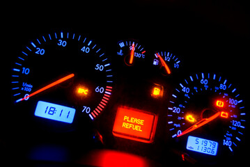 car dashboard showing refuel light illuminated.