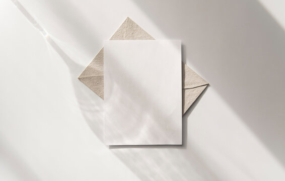 Mockup blank greeting card. Composition with shadows from a glass goblet on white background. 
