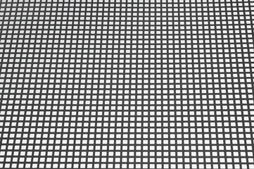 gray background, in the photo a metal grid with square cells on a gray background.