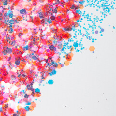 Pink and blue glitter grains on white background