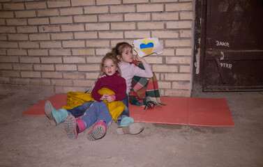 Fototapeta premium KIEV, UKRAINE - March 24, 2022: The war in Ukraine. the life of children in a bomb shelter at a metro station in Ukraine.