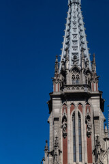 Fototapeta na wymiar Peak of gothic style catholic church with blue sky in back