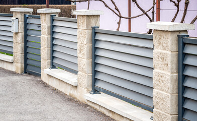 Modern stone fence with aluminum or metal shutter