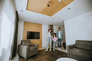 Young family arrive into hotel room
