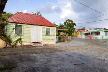 Fototapeta na wymiar Small house with a light green wooden facade in the suburbs of Willemstad, Curacao