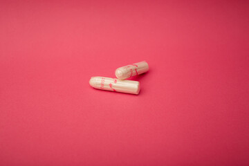 Medical female tampon on a pink background. Hygienic white tampon for women. Cotton swab. Menstruation, means of protection.