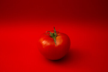 Red tomato on a red background