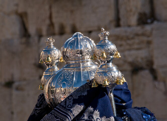 Ornate silver pieces and colorful fabrics adorn the round casing traditionally used by Sefardic...