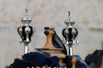 Ornate silver pieces and colorful fabrics adorn the round casing traditionally used by Sefardic...