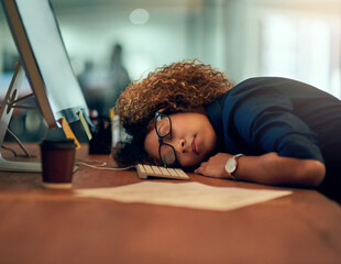 Game over. Shot of an exhausted young businesswoman sleeping at her desk during a late night at...