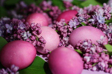 Obraz na płótnie Canvas Close-up of beautiful lilac Easter eggs with blooming lilac branches. Easter decor. Selective focus.