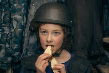 A child in a helmet hides in the basement from the shooting. A girl eats bread in a bomb shelter...