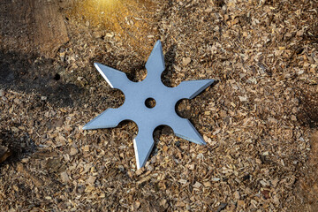 Shuriken (throwing star), traditional japanese ninja cold weapon stuck in wooden background
