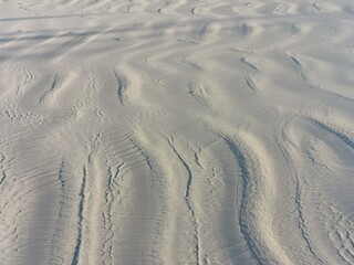 Obraz premium Sand on the Beach, shadows and sun light on sand, Wind pattern on sand rains at Beach