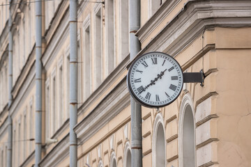 Fototapeta na wymiar City clock on the wall of a house in St. Petersburg