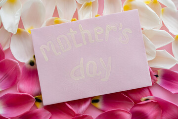top view of envelope with mothers day lettering on white and pink floral petals.