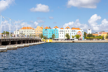 The famous Queen-Emma-Bridge with colorful buildings of the district Otrobanda in Willemstad,...