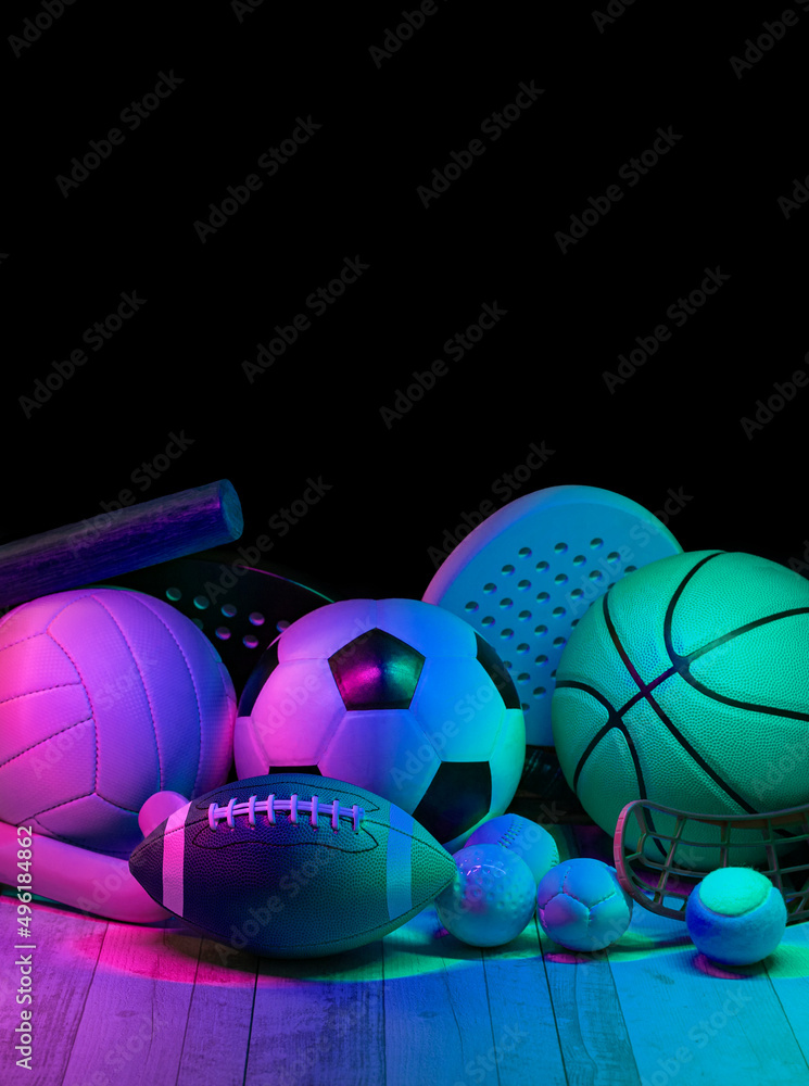 Wall mural sports equipment, rackets and balls on hardwood court floor with neon light background. vertical edu