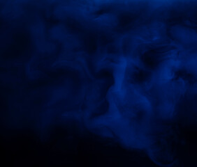 Abstract background of chaotically mixing puffs of smoke on a dark background