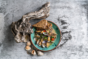 Mussels in copper pot and white wine on stone table. Top view