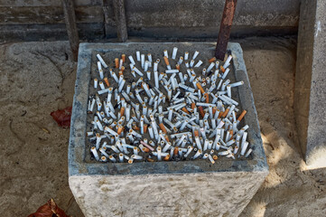 Big jar full of remains of cigarettes at beach in Phuket, Thailand.