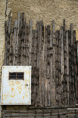 Metal box on wooden and stone wall