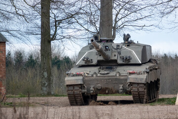 british army challenger 2 II FV4034 main battle tank stationary between empty buildings, awaiting deployment
