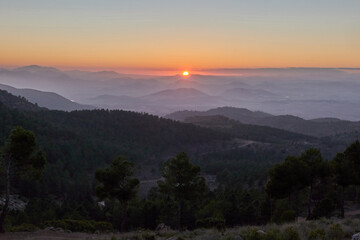 Obraz premium Nice sunset between mountains. Pedro ponce mountains sunset with a dense forest mainly of pine trees.It is located between the municipal districts of Mula and Lorca, Murcia, Spain.