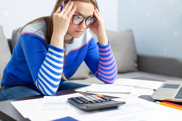 Stressed young brunet woman sits at home manage household finances frustrated with family financial problems. Distressed upset female disappointed with money debt, pays bills taxes online on laptop - Powered by Adobe