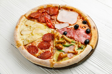 Assorted Italian pizza on a white wooden table. Different pieces in one portion - set
