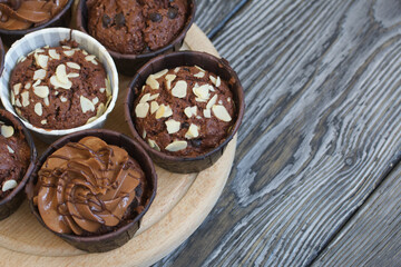 Chocolate muffins with different fillings. On black pine boards. Shot close-up.