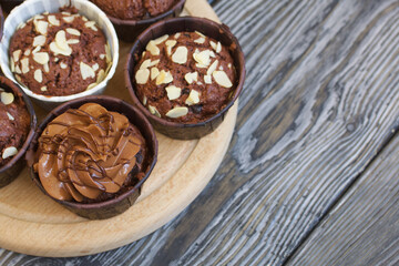 Chocolate muffins with different fillings. On black pine boards. Shot close-up.