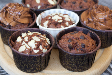 Chocolate muffins with different fillings. On pine boards. Shot close-up.
