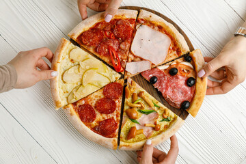 Assorted Italian pizza on a white wooden table. Different pieces in one portion - set
