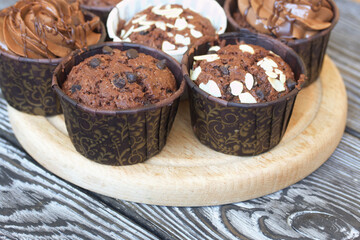Chocolate muffins with different fillings. On black pine boards. Shot close-up.