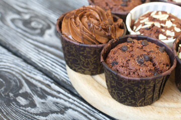 Chocolate muffins with different fillings. On black pine boards. Shot close-up.